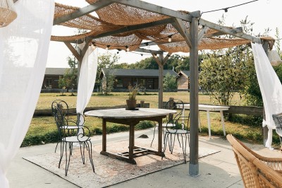 Centre de table avec fleurs séchées dans un bol en céramique et une carte indiquant ’Table Amitié’ sur une rondelle de bois.