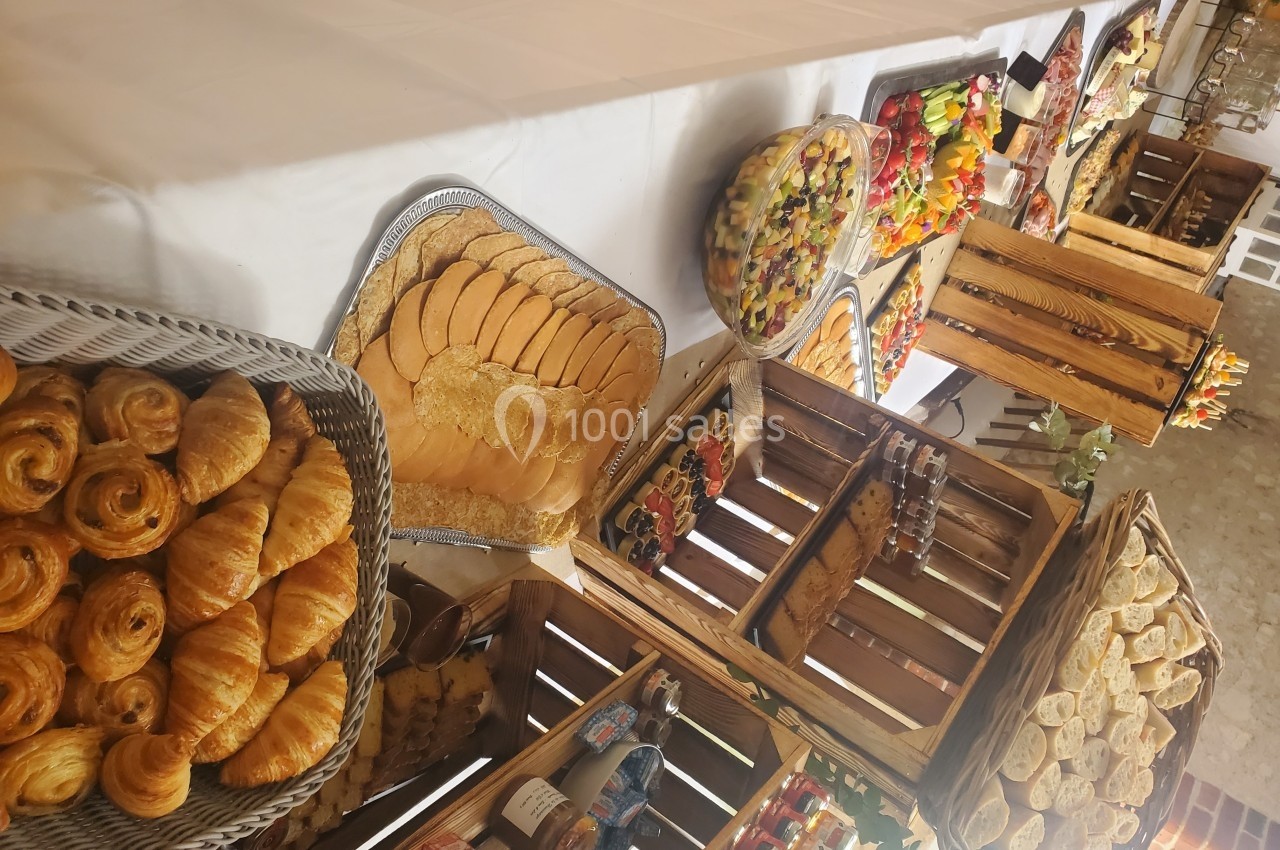 Location salle Les Villages Vovéens (Eure-et-Loir) - Hôtel Restaurant le Quai Fleuri #12 Buffet composé de viennoiseries, pain, fruits frais et brochettes, présenté sur une table avec des caisses en bois.
