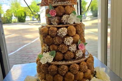 Salle de restaurant lumineuse avec tables dressées, chaises en bois sombre, étagères décoratives et plantes vertes.