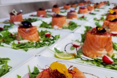 Miniature Traiteur Les Villages Vovéens (Eure-et-Loir) - Le Quai Fleuri #5 Camion noir de traiteur ’Le Quai Fleuri’ garé devant un bâtiment, avec visuels de prestations culinaires sur les panneaux.