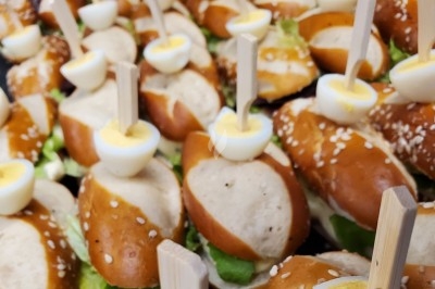 Miniature Traiteur Les Villages Vovéens (Eure-et-Loir) - Le Quai Fleuri #6 Camion noir de traiteur ’Le Quai Fleuri’ garé devant un bâtiment, avec visuels de prestations culinaires sur les panneaux.