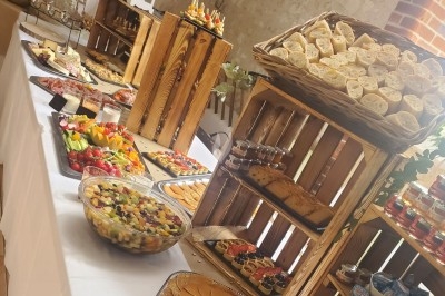 Miniature Traiteur Les Villages Vovéens (Eure-et-Loir) - Le Quai Fleuri #4 Camion noir de traiteur ’Le Quai Fleuri’ garé devant un bâtiment, avec visuels de prestations culinaires sur les panneaux.