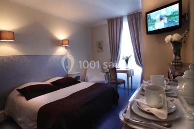 Façade d'un hôtel ancien à plusieurs étages, avec des fenêtres symétriques et un ciel bleu dégagé en arrière-plan.