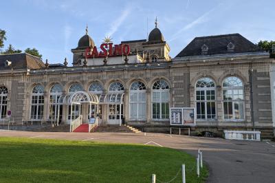 Façade d'un hôtel ancien à plusieurs étages, avec des fenêtres symétriques et un ciel bleu dégagé en arrière-plan.