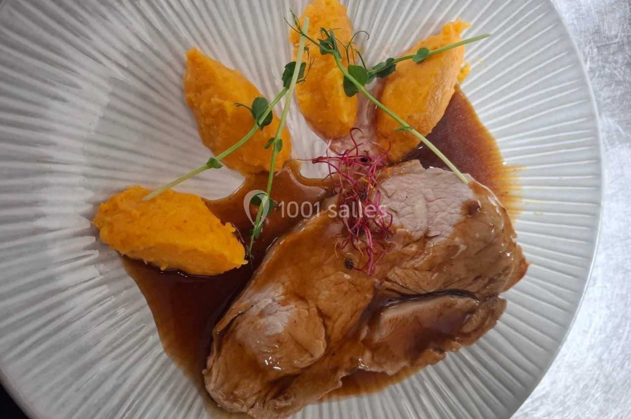 Location salle Contrexéville (Vosges) - Casino Partouche de Contrexéville #15 Assiette avec des tranches de viande nappées de sauce, accompagnées de purée de carottes et décorées de pousses.