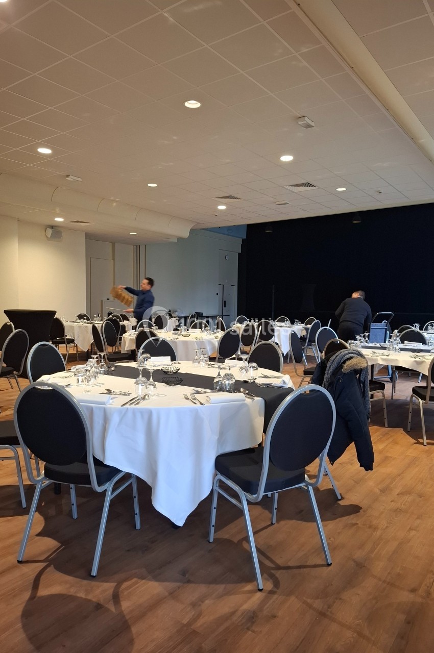 Location salle Contrexéville (Vosges) - Casino Partouche de Contrexéville #20 Salle de réception avec des tables rondes dressées, un homme disposant des éléments sur une table.