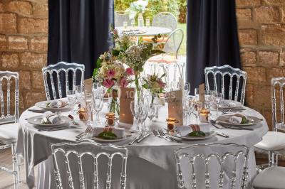 Miniature Location salle Gouvieux (Oise) - Château Jeanne & The Forest - Château de Montvillargenne #7 Un couple en tenue de mariage se tient devant une porte illuminée, entouré de briques et de végétation.