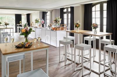 Miniature Location salle Gouvieux (Oise) - Château Jeanne & The Forest - Château de Montvillargenne #15 Un couple en tenue de mariage se tient devant une porte illuminée, entouré de briques et de végétation.