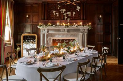 Miniature Location salle Gouvieux (Oise) - Château Jeanne & The Forest - Château de Montvillargenne #8 Un couple en tenue de mariage se tient devant une porte illuminée, entouré de briques et de végétation.