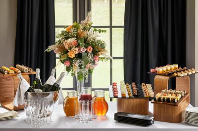 Miniature Location salle Gouvieux (Oise) - Château Jeanne & The Forest - Château de Montvillargenne #13 Un couple en tenue de mariage se tient devant une porte illuminée, entouré de briques et de végétation.