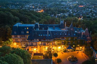 Miniature Location salle Gouvieux (Oise) - Château Jeanne & The Forest - Château de Montvillargenne #26 Un couple en tenue de mariage se tient devant une porte illuminée, entouré de briques et de végétation.
