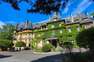 Miniature Location salle Gouvieux (Oise) - Château Jeanne & The Forest - Château de Montvillargenne #4 Un couple en tenue de mariage se tient devant une porte illuminée, entouré de briques et de végétation.