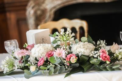 Miniature Location salle Gouvieux (Oise) - Château Jeanne & The Forest - Château de Montvillargenne #10 Un couple en tenue de mariage se tient devant une porte illuminée, entouré de briques et de végétation.