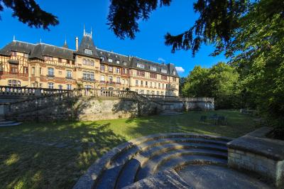 Miniature Location salle Gouvieux (Oise) - Château Jeanne & The Forest - Château de Montvillargenne #23 Un couple en tenue de mariage se tient devant une porte illuminée, entouré de briques et de végétation.