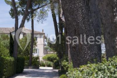 Miniature Location salle Sorgues (Vaucluse) - Château La Tour Vaucros #3 Terrain de tennis en plein air entouré de végétation et d'arbres, avec une clôture grillagée.