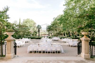 Miniature Location salle Le Cannet-des-Maures (Var) - Château Colbert Cannet #7 Un couple danse sous des guirlandes lumineuses devant un bâtiment éclairé en rouge, de nuit.