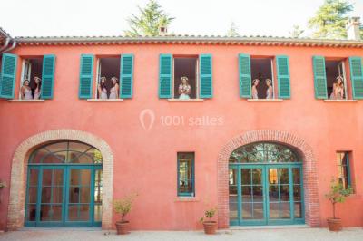 Miniature Location salle Le Cannet-des-Maures (Var) - Château Colbert Cannet #8 Un couple danse sous des guirlandes lumineuses devant un bâtiment éclairé en rouge, de nuit.