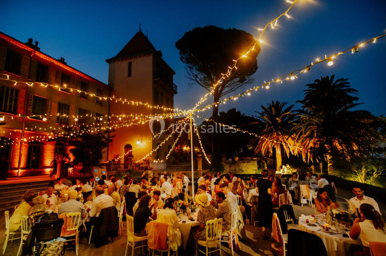 Location salle Le Cannet-des-Maures (Var) - Château Colbert Cannet #11 Dîner en plein air sous des guirlandes lumineuses, avec des invités assis autour de tables dans un cadre festif.