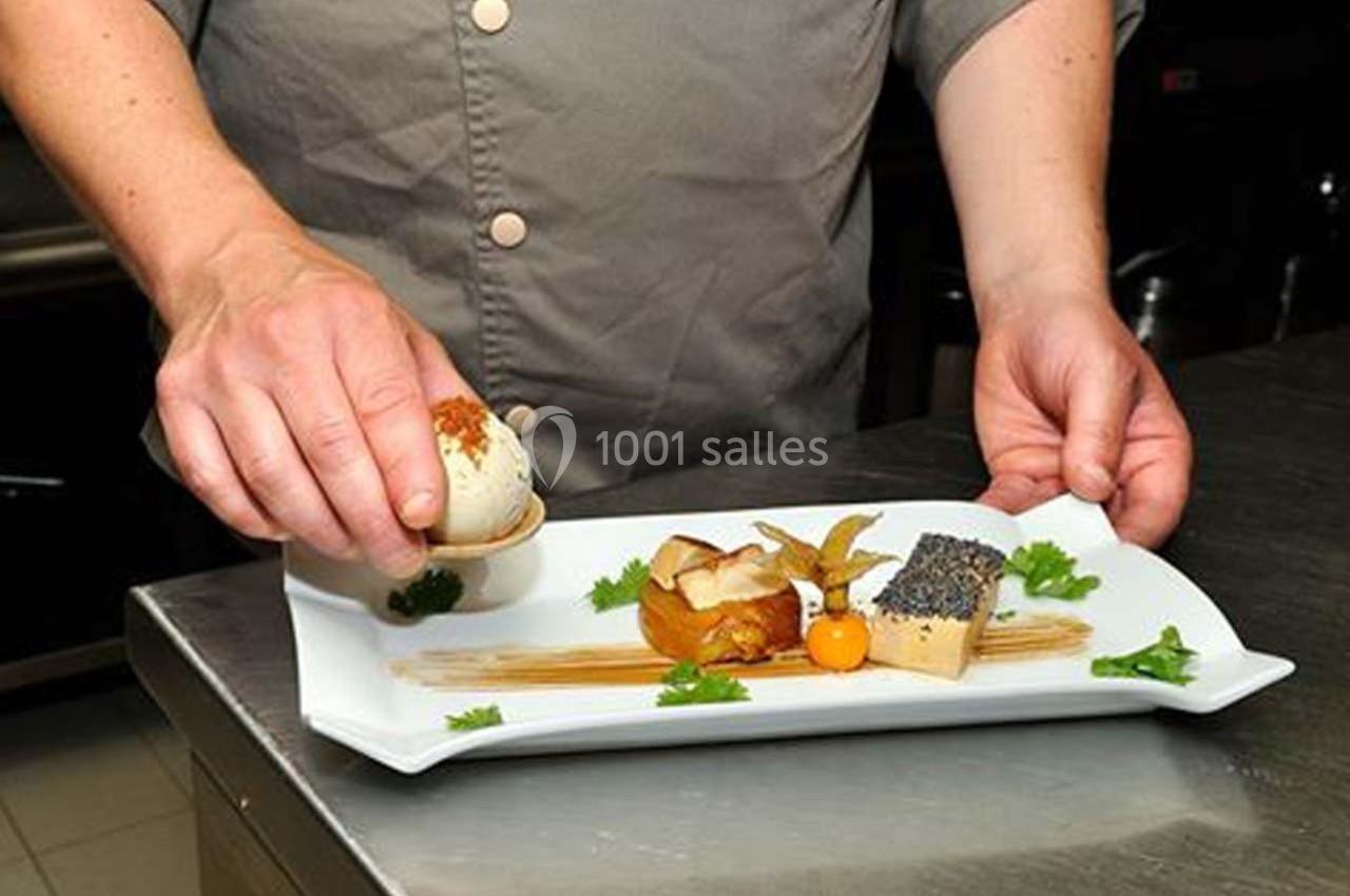 Location salle Bonneval (Eure-et-Loir) - Auberge de La Herse #7 Un chef dispose soigneusement des éléments d'un plat gastronomique sur une assiette blanche.