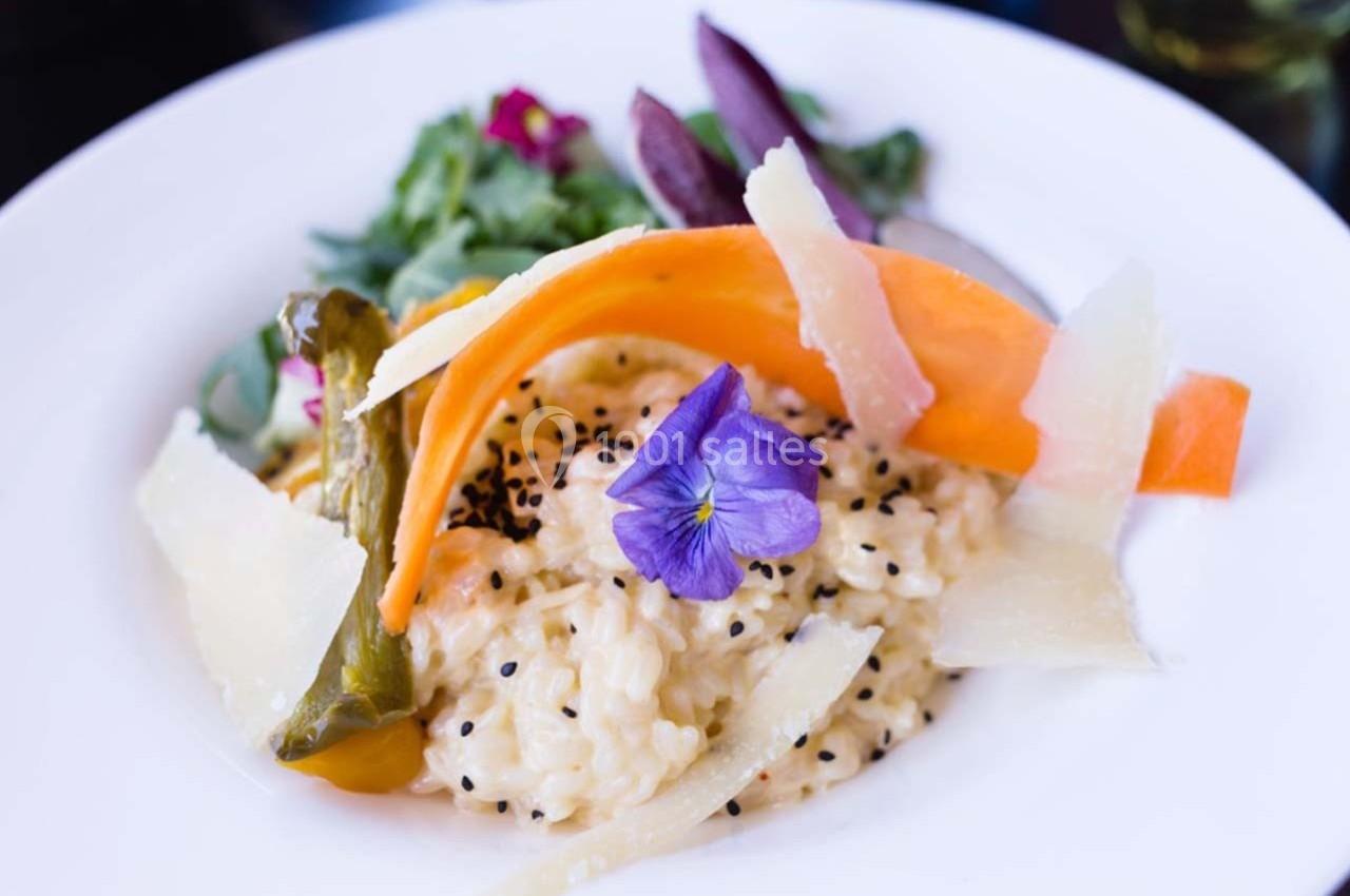 Location salle Bonneval (Eure-et-Loir) - Auberge de La Herse #13 Assiette de risotto crémeux garni de légumes colorés, copeaux de parmesan et une fleur comestible violette.