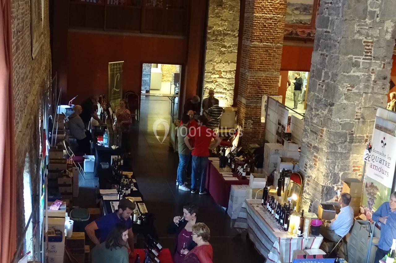 Location salle Anhée (Namur) - Ferme de l'Abbaye de Moulins #40 Vue d'un marché couvert avec des stands de produits locaux, des visiteurs et une architecture en pierre et bois.