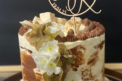 Gâteau d'anniversaire rose décoré de macarons, ballons comestibles dorés et blancs, avec un topper ’Happy Birthday 30’.