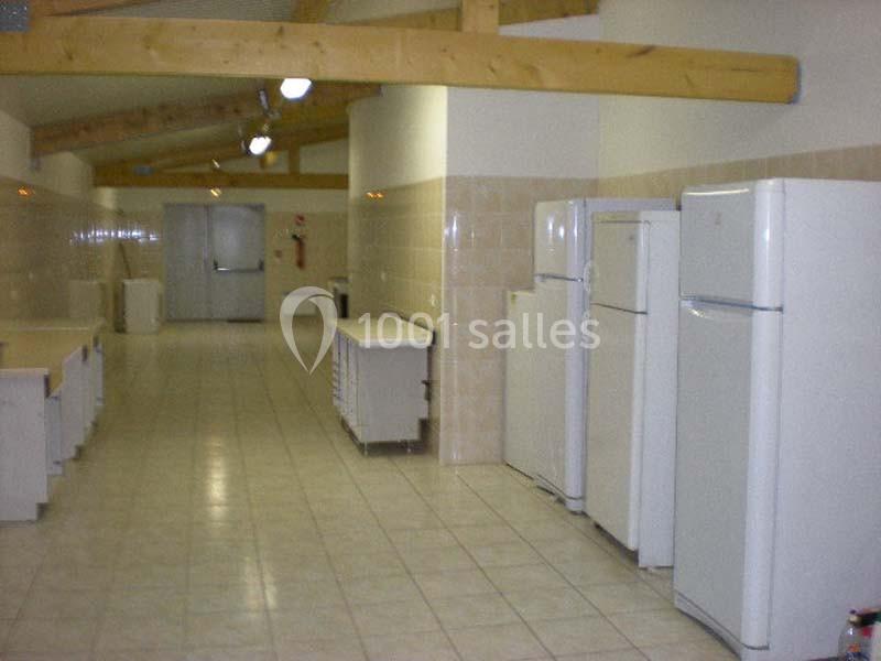 Location salle Nanteuil-lès-Meaux (Seine-et-Marne) - Centre D #27 Cuisine collective avec plusieurs réfrigérateurs blancs alignés, plans de travail et plafond avec poutres apparentes.