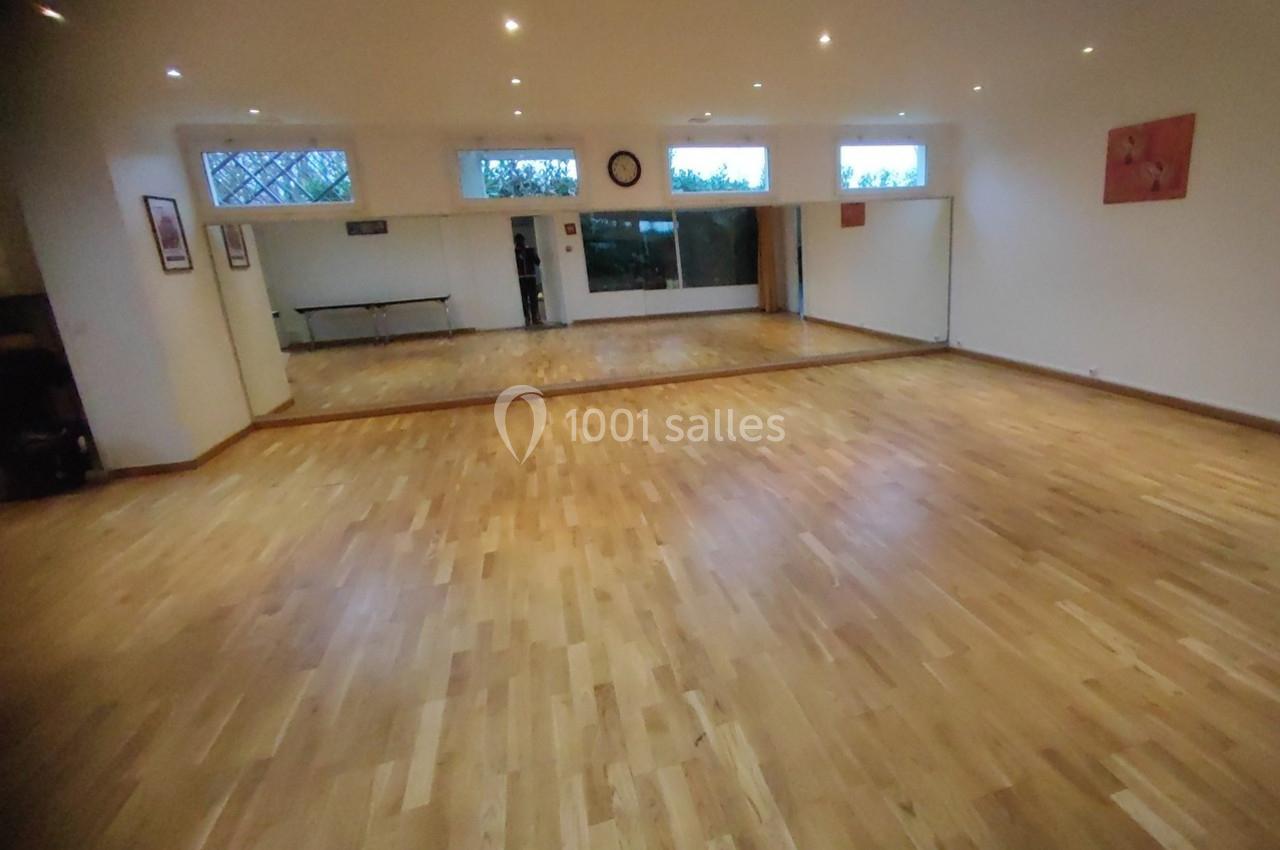 Location salle Nanteuil-lès-Meaux (Seine-et-Marne) - Centre D #22 Salle lumineuse avec parquet en bois clair, murs blancs, miroirs sur un mur et fenêtres en hauteur.
