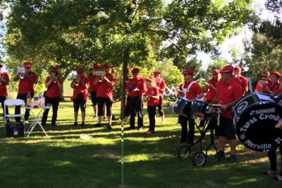Jardin avec pelouse, arbres et pot en terre cuite au premier plan, éclairé par une lumière douce en fin de journée.