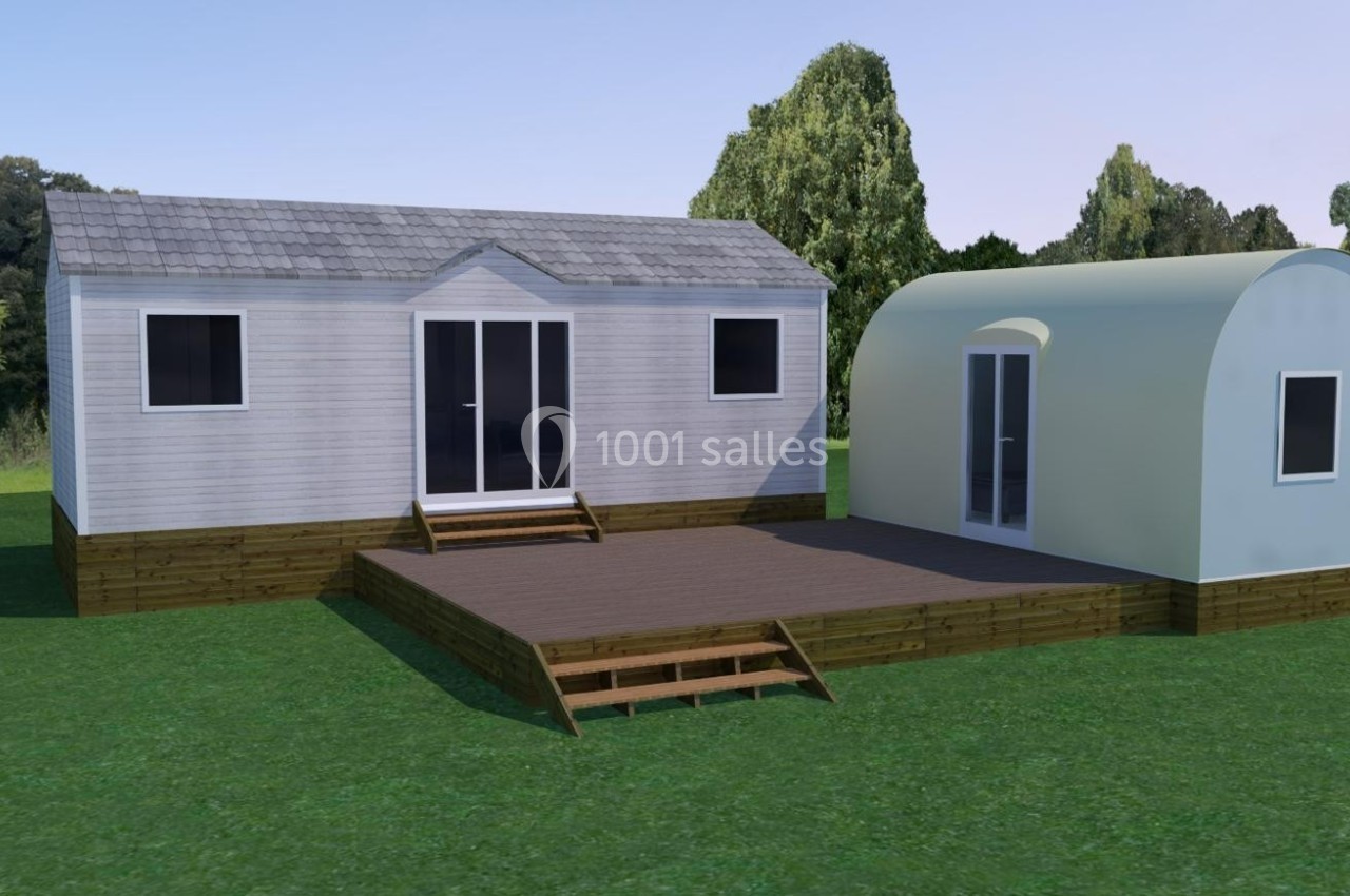 Location salle Monferran-Savès (Gers) - Le Meillon #24 Deux modules préfabriqués en bois avec terrasse, situés sur une pelouse entourée d'arbres.