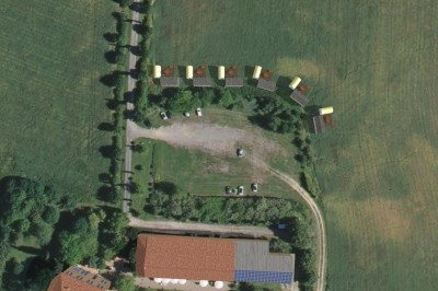 Miniature Location salle Monferran-Savès (Gers) - Le Meillon #26 Vue aérienne d'un terrain avec des bâtiments, des véhicules stationnés et des structures alignées en bordure d'un champ.