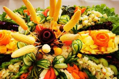 Assiette garnie de légumes variés, morceaux de viande et sauce rouge au centre, présentée sur un lit de salade.