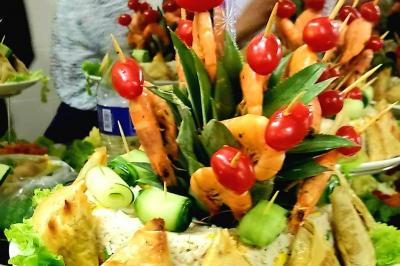 Assiette garnie de légumes variés, morceaux de viande et sauce rouge au centre, présentée sur un lit de salade.