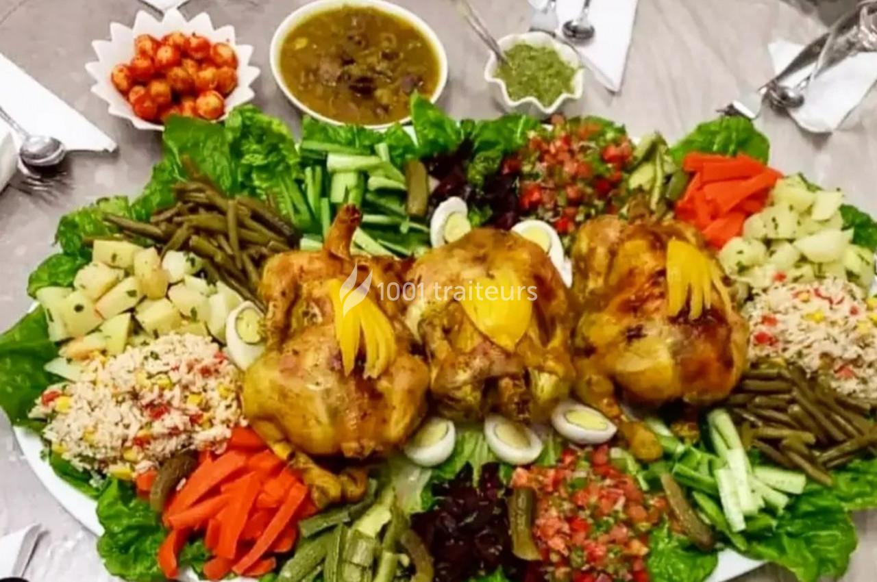 Plat composé de trois poulets rôtis entourés de légumes variés, salade, riz et condiments sur une grande assiette.