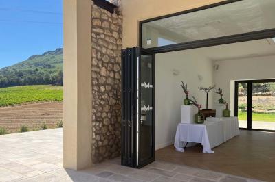 Miniature Location salle Artigues (Var) - Domaine de la Mongestine #34 Bouteille de vin rosé entourée de verres vides sur une table en bois, avec une plante en arrière-plan.