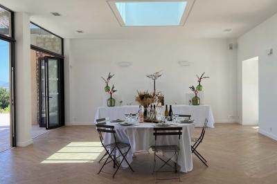 Miniature Location salle Artigues (Var) - Domaine de la Mongestine #16 Bouteille de vin rosé entourée de verres vides sur une table en bois, avec une plante en arrière-plan.