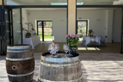 Miniature Location salle Artigues (Var) - Domaine de la Mongestine #13 Bouteille de vin rosé entourée de verres vides sur une table en bois, avec une plante en arrière-plan.