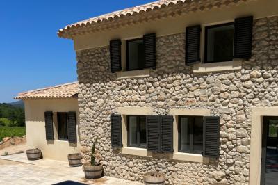 Miniature Location salle Artigues (Var) - Domaine de la Mongestine #8 Bouteille de vin rosé entourée de verres vides sur une table en bois, avec une plante en arrière-plan.