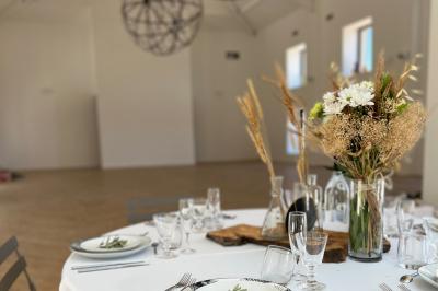 Miniature Location salle Artigues (Var) - Domaine de la Mongestine #18 Bouteille de vin rosé entourée de verres vides sur une table en bois, avec une plante en arrière-plan.