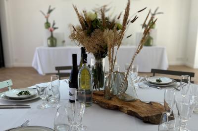 Miniature Location salle Artigues (Var) - Domaine de la Mongestine #19 Bouteille de vin rosé entourée de verres vides sur une table en bois, avec une plante en arrière-plan.