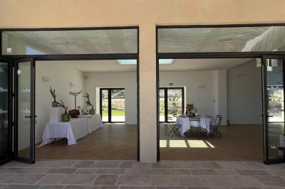 Miniature Location salle Artigues (Var) - Domaine de la Mongestine #37 Bouteille de vin rosé entourée de verres vides sur une table en bois, avec une plante en arrière-plan.