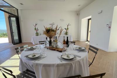 Miniature Location salle Artigues (Var) - Domaine de la Mongestine #17 Bouteille de vin rosé entourée de verres vides sur une table en bois, avec une plante en arrière-plan.