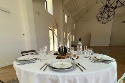 Miniature Location salle Artigues (Var) - Domaine de la Mongestine #21 Bouteille de vin rosé entourée de verres vides sur une table en bois, avec une plante en arrière-plan.