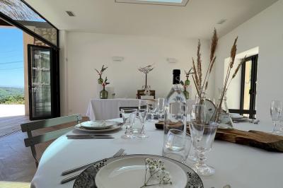 Miniature Location salle Artigues (Var) - Domaine de la Mongestine #15 Bouteille de vin rosé entourée de verres vides sur une table en bois, avec une plante en arrière-plan.