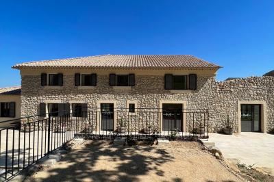Miniature Location salle Artigues (Var) - Domaine de la Mongestine #38 Bouteille de vin rosé entourée de verres vides sur une table en bois, avec une plante en arrière-plan.