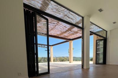 Miniature Location salle Artigues (Var) - Domaine de la Mongestine #41 Bouteille de vin rosé entourée de verres vides sur une table en bois, avec une plante en arrière-plan.