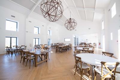 Miniature Location salle Artigues (Var) - Domaine de la Mongestine #25 Bouteille de vin rosé entourée de verres vides sur une table en bois, avec une plante en arrière-plan.