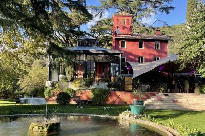 Main d'une personne tenant légèrement une robe blanche, avec un bracelet fin et une bague visible.