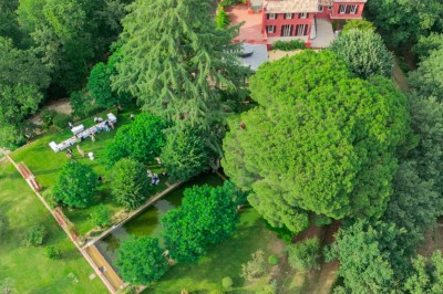 Main d'une personne tenant légèrement une robe blanche, avec un bracelet fin et une bague visible.