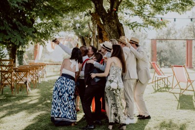 Main d'une personne tenant légèrement une robe blanche, avec un bracelet fin et une bague visible.